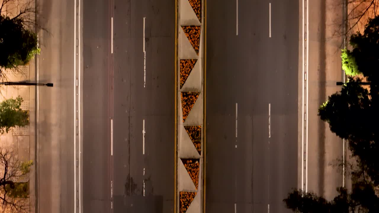 Aerial shot of a car being towed along the central lanes of Paseo de la Reforma, with the median decorated for the Day of the Dead celebration in Mexico City