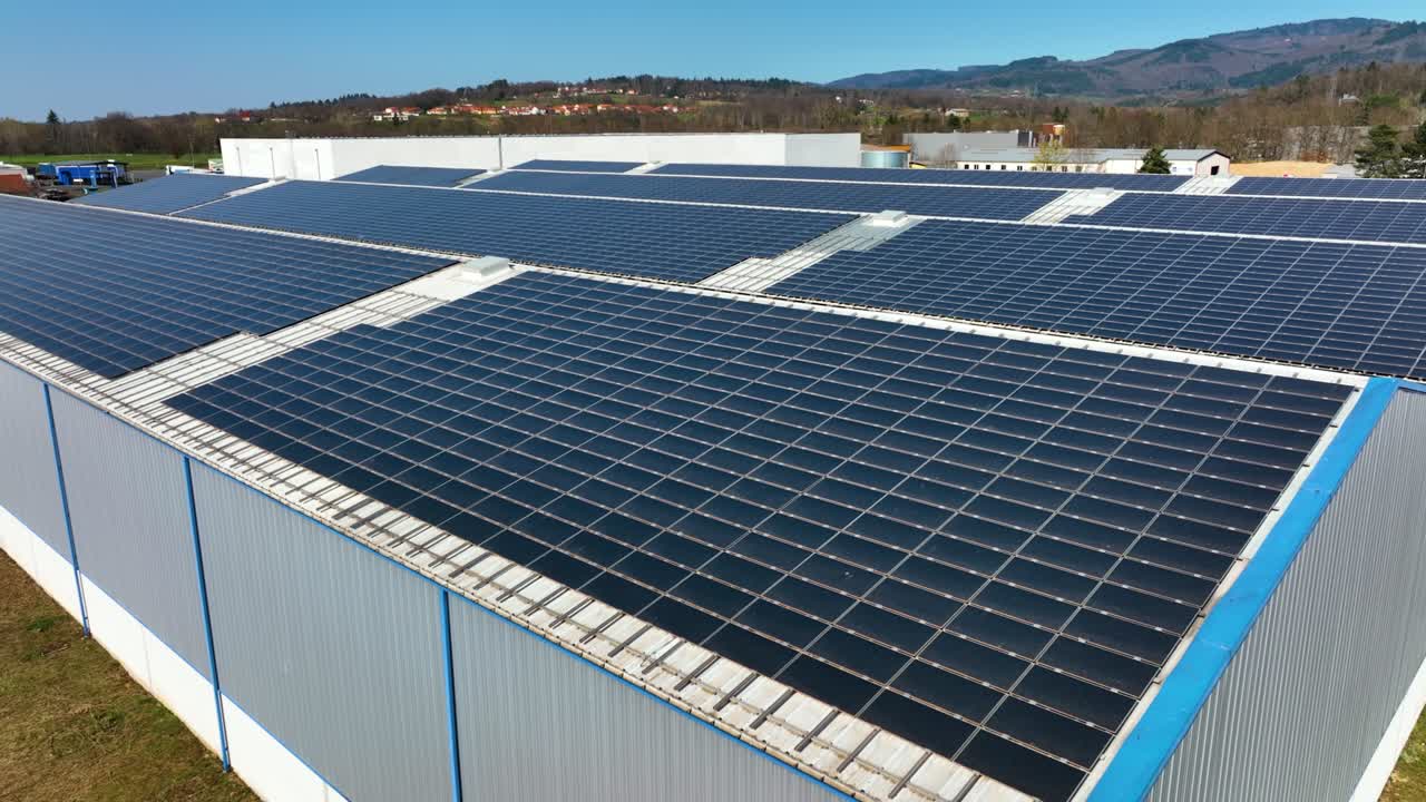 산업용 건물 지붕에 장착된 파란색 광전지 패널을 가진 태양광 발전소의 공중 전망 - 녹색 생태적 전기를 생산하기 위해 지속 가능한 에너지 개념의 생산