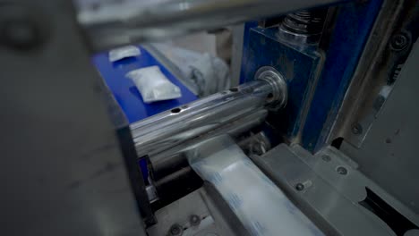 overlooking soap bars being sealed in packaging along conveyor belt in factory