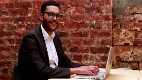 Casual-businessman-typing-at-his-desk