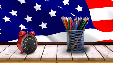 american flag with alarm clock and pencils