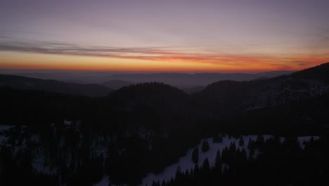 captivating aerial view of a sunset over snow-covered mountains, showcasing vibrant skies and peaceful winter landscapes