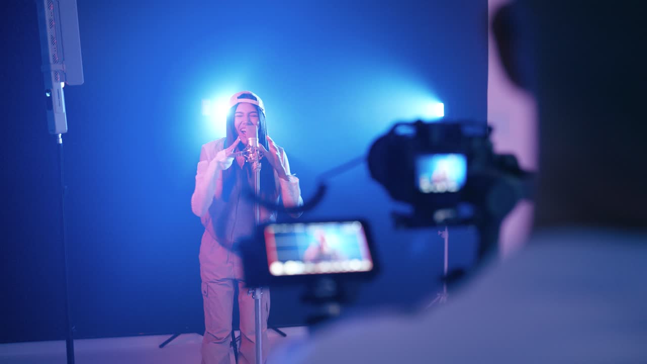 Cameraman che filma una giovane cantante rap in studio