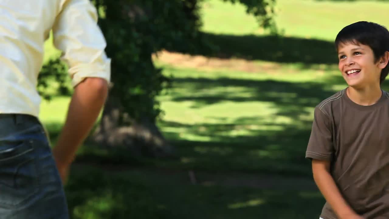 아버지 와 아들 이 공 을 가지고 놀고 있다