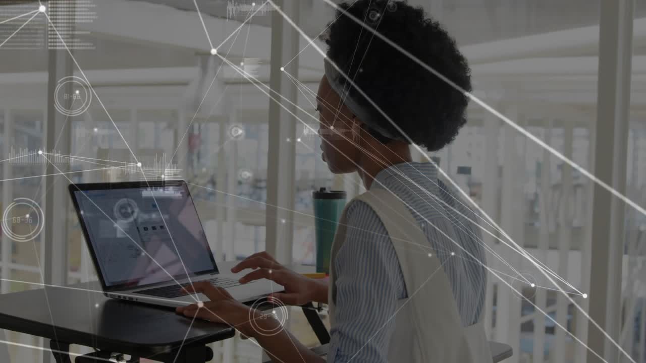 Woman typing and tapping laptop at standing desk in business, activating HUD overlay analyzing data