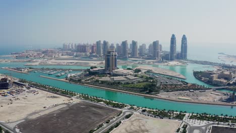 Lusail-marina-in-qatar-with-clear-skies-and-urban-skyline,-aerial-view