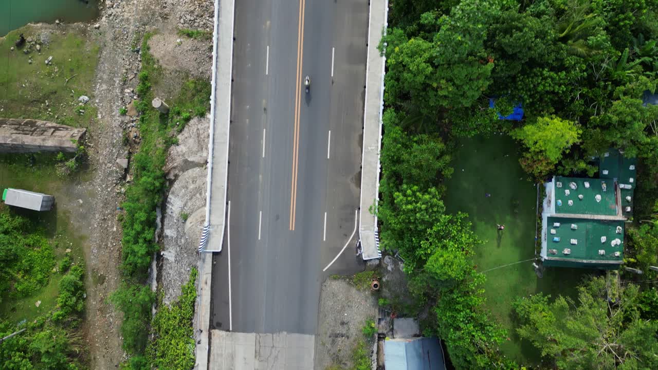Aerial top-down view of bridge crossing Sto Domingo calm river with lush greenery at barangay village Bigaa, Virac, Catanduanes