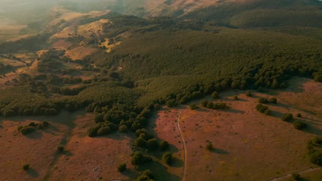 beautiful plain with green vegetation in the morning at dawn in the majella mountains, abruzzo, italy. - aerial panoramic drone shot