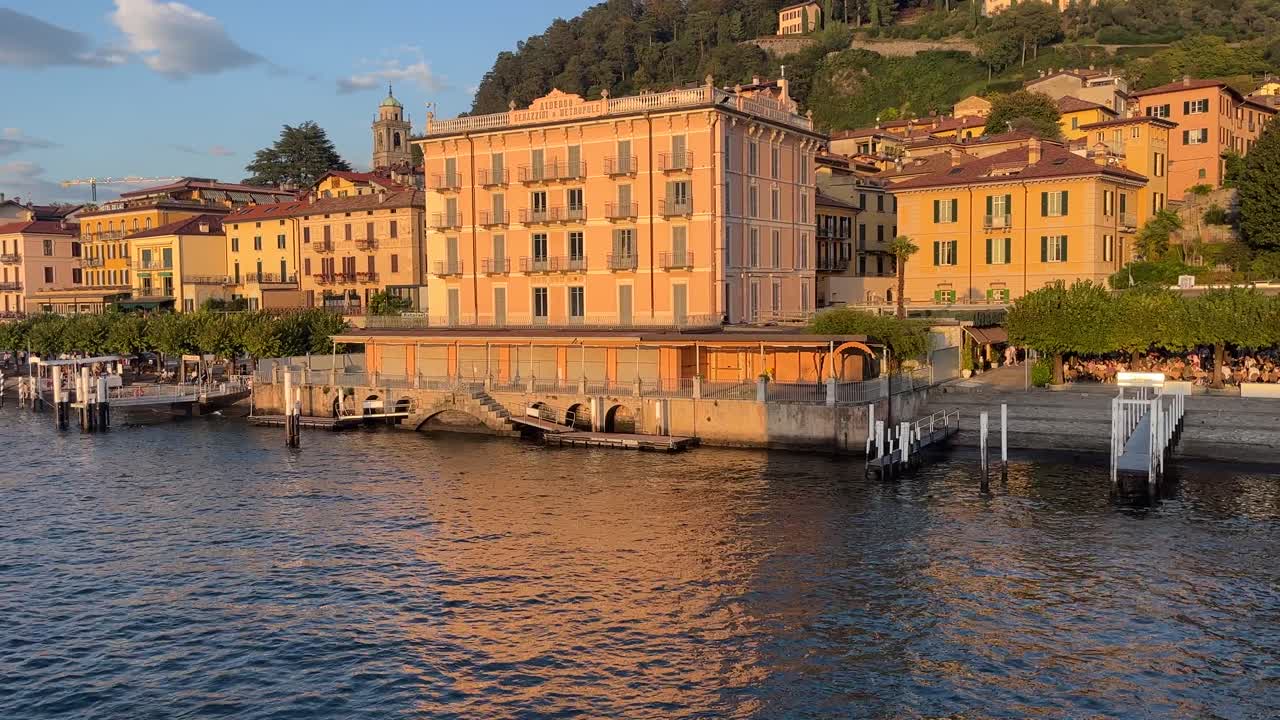 주말에 해가 지는 동안 벨라지오라고 불리는 코모 호수에 있는 작은 이탈리아 마을의 크고 노란색 아파트 건물의 영화 비디오