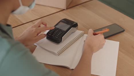 unrecognizable waitress making financial report