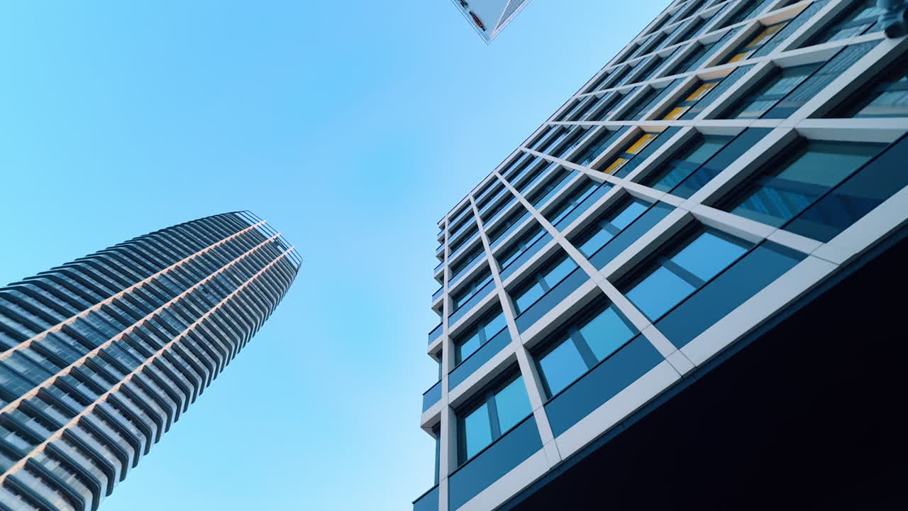 Bratislava, Slovakia - June 5, 2025: Modern architecture reaches for the sky. Looking up at contemporary skyscrapers against a clear blue sky in an urban setting during the day