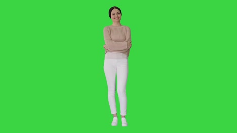 smiling young woman posing with arms crossed on a green screen, chroma key