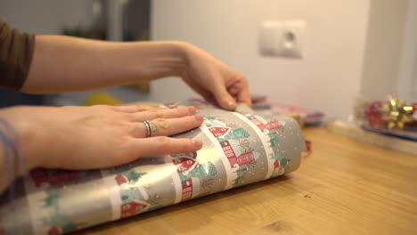 packing a silver wool sweater or scarf into christmas decoration paper in december