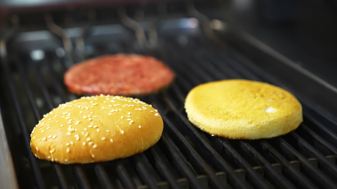 Top view of the delicious burger cutlet and fresh buns grilled on barbeque. Delicious dish freshly made on grid.
