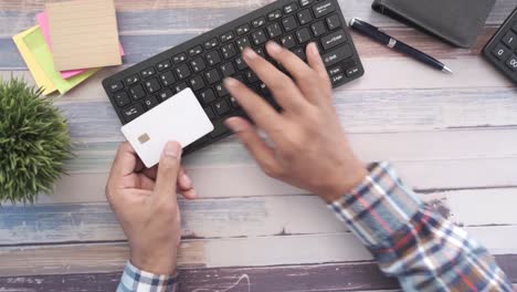 person using a credit card on a computer keyboard