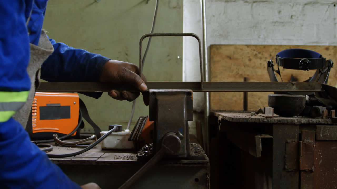 fabbro che lavora su una macchina in officina 4k