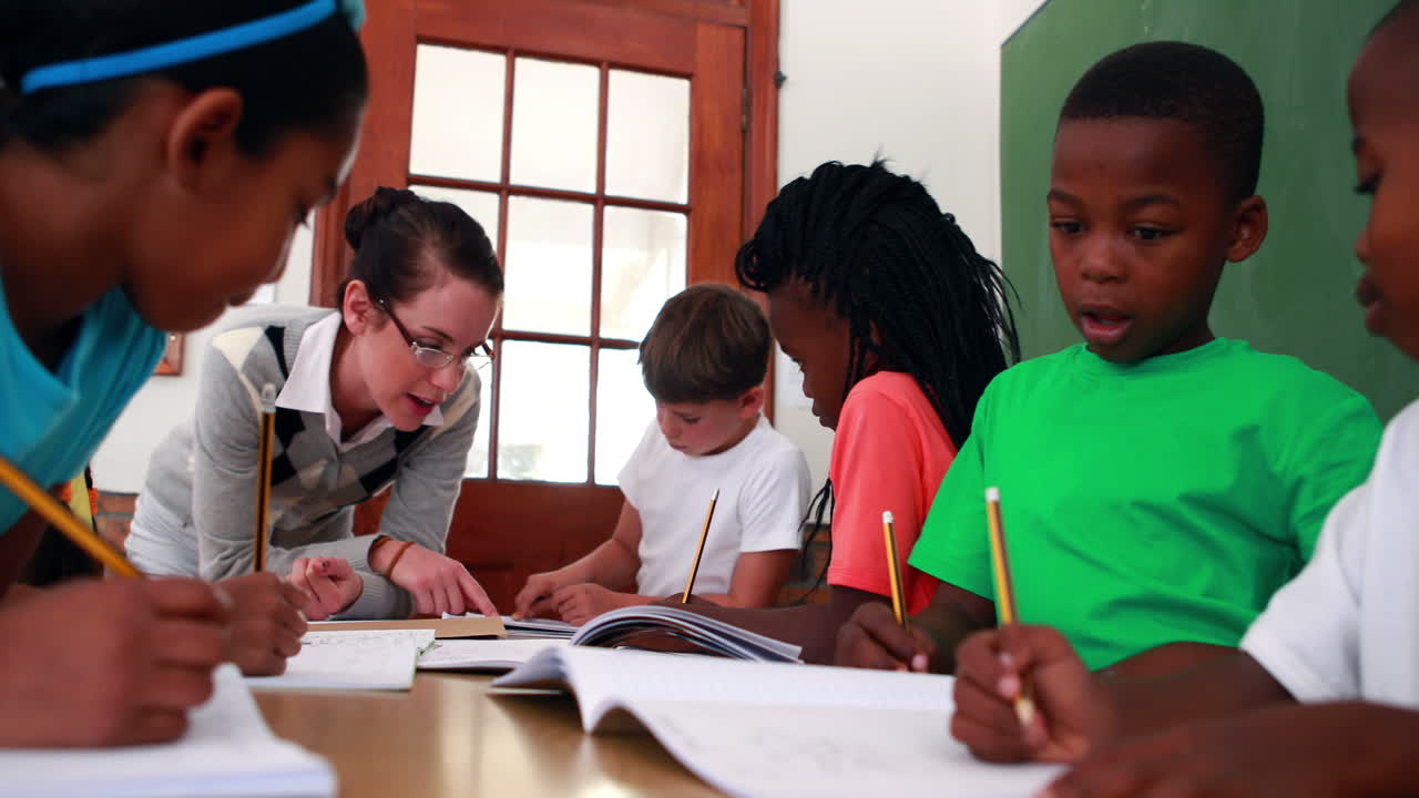 maestra ayudando a sus alumnos durante la clase