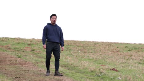 asian male walks down hill