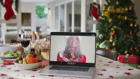 Glückliche-Kaukasische-Frau-Mit-Weihnachtsmütze-Auf-Laptop,-Die-Auf-Dem-Weihnachtstisch-Liegt
