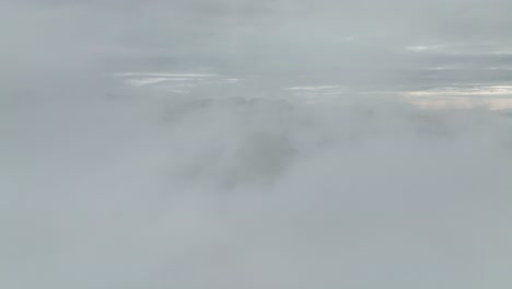 aerial view of mountain peaks emerging through thick clouds at hafursey, iceland, creating a dramatic and serene scene under a cloudy sky.