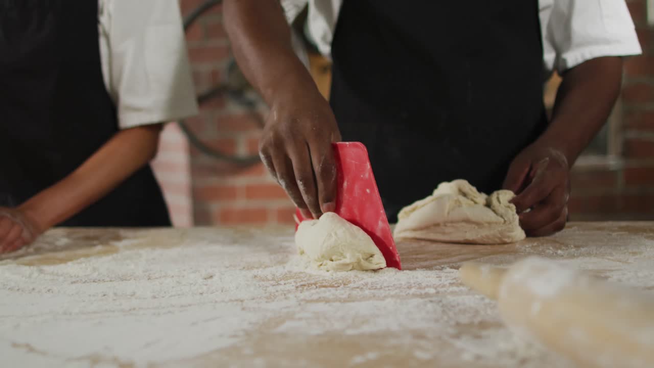 Animation of hands of diverse male and female bakers cutting sourdough for bread