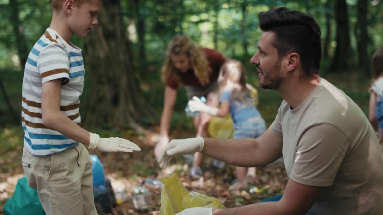 un chico caucásico limpiando el bosque de basura con su familia.