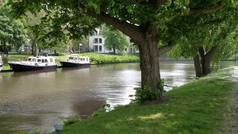 old church tower oldehove leeuwarden fast dolly shot in front the river ee with moored boats in the park