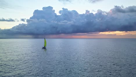 un catamarán solitario surcando el océano con una formación de tormenta al amanecer