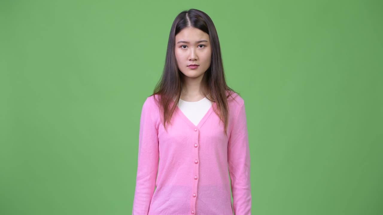 Young beautiful Asian woman giving thumbs down