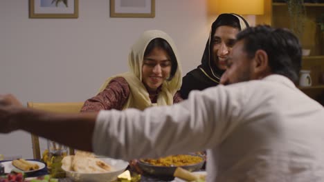 Muslimische-Familie-Sitzt-Zu-Hause-Am-Tisch-Mit-Essen-Zum-Essen-Und-Feiert-Eid-Und-Posiert-Für-Selfie-2