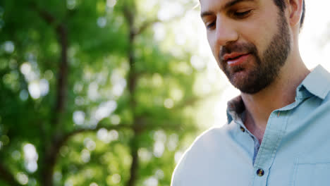 Man-using-digital-tablet-in-the-park-on-a-sunny-day