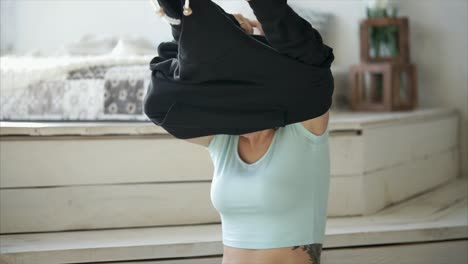 woman putting on and dancing in a hoodie