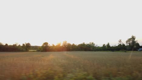 car window view driving through farm country in upstate new york motion blurred through the fields on a road trip