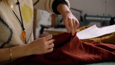 seamstress pinning together fabric shirt in preparation for sewing in slow fashion design studio