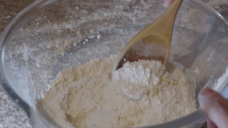 revolviendo el agua, el aceite de oliva y la harina en un recipiente de vidrio