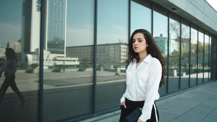 Stylish businesswoman walking in slow motion outdoors