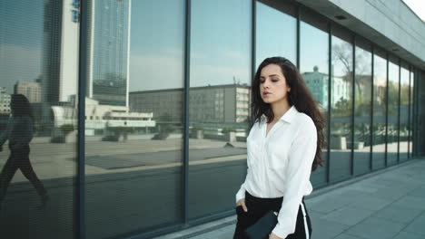 stylish businesswoman walking in slow motion outdoors