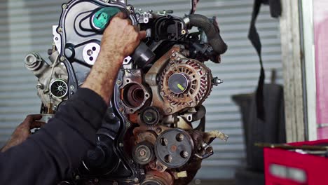 car mechanic assembles parts of car engine with cordless screwdriver in the repair shop