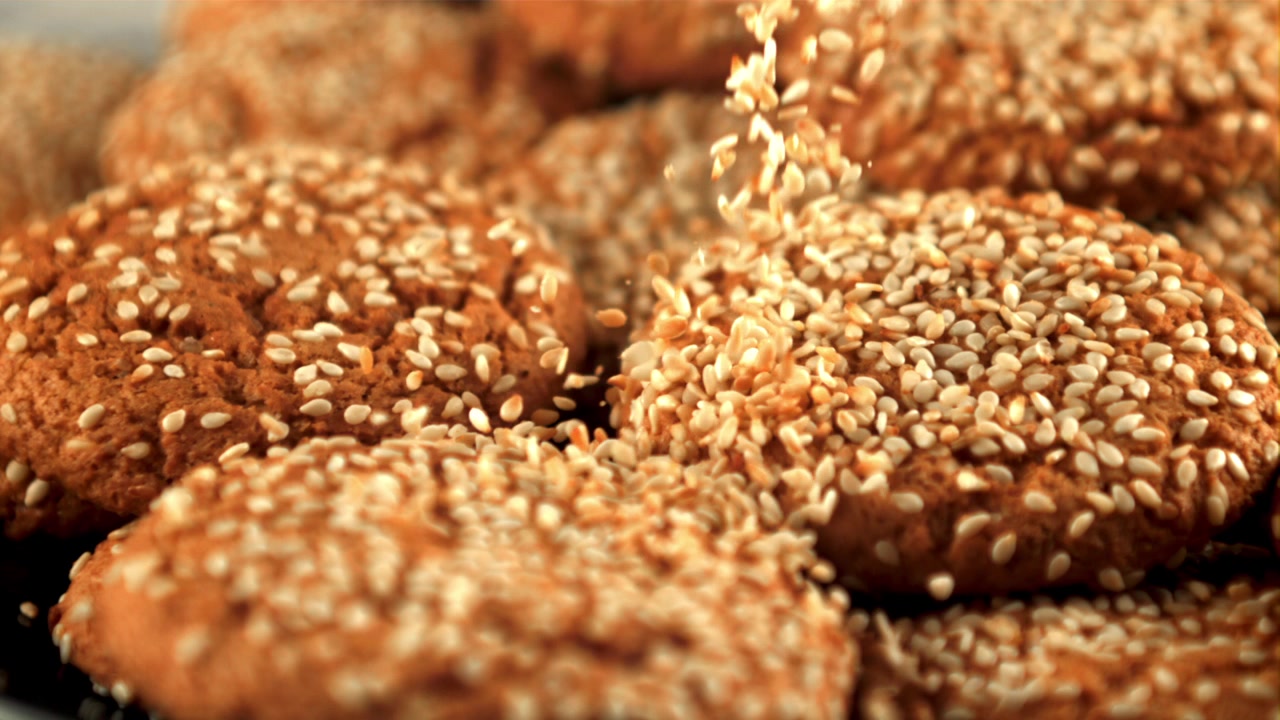 Slow Motion of Sesame Seeds Falling on Freshly Baked Cookies