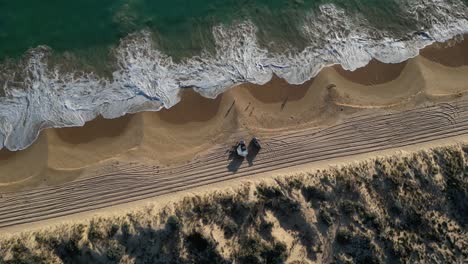 top down view over preston beach where white waves roll foaming on the sand