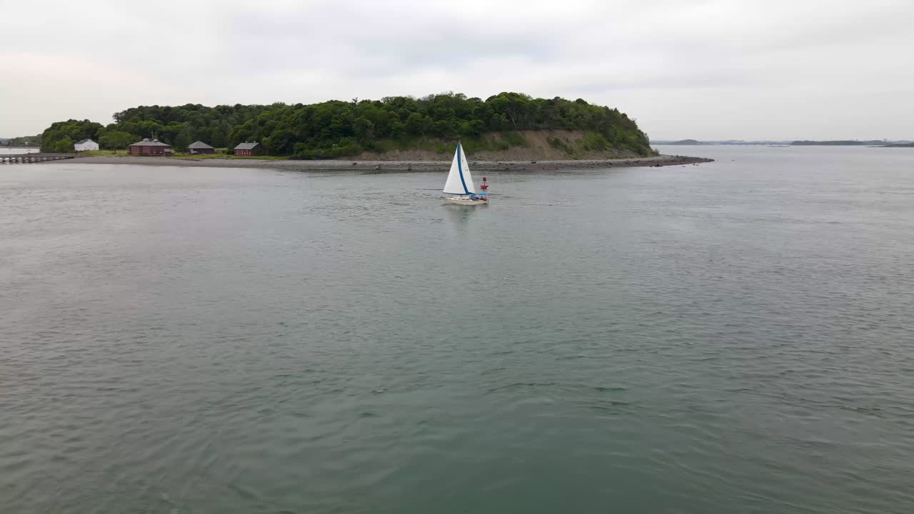 круговой обзор яхты в центре кадра, остров на заднем плане, вдали - бостон