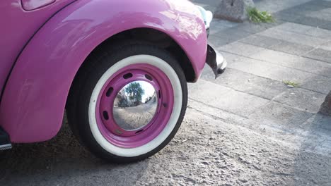 pink vintage volkswagen beetle on the street