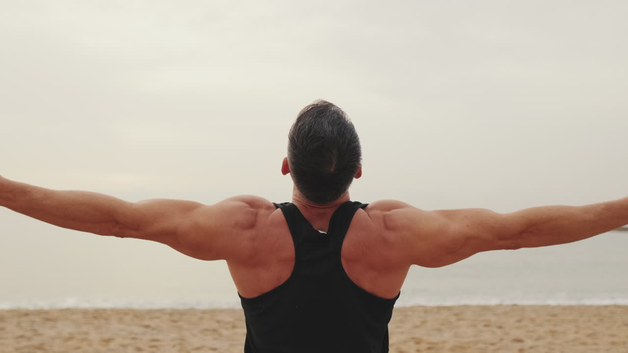 Man doing yoga on the beach