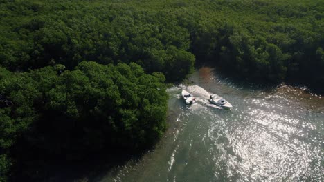 cerca de un accidente de navegación entre dos lanchas motoras que se cruzan mientras se mueven a través del bosque de manglares en los canales de agua de la riviera maya, méxico creando una estela en el agua del océano
