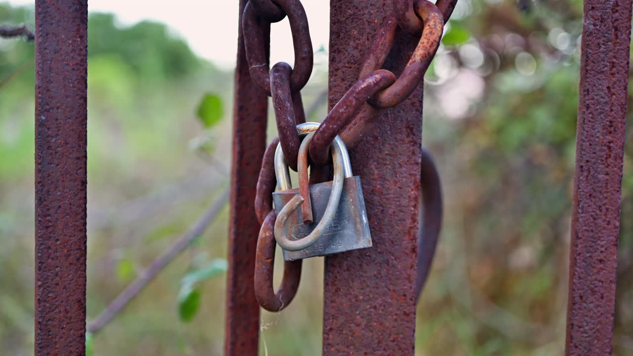 Close up of a lock closing a rusty gate