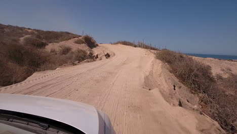 POV-footage-of-car-driving-on-dirt-road-along-ridge-of-oceanfront-at-Cabo-San-Lucas,-Mexico