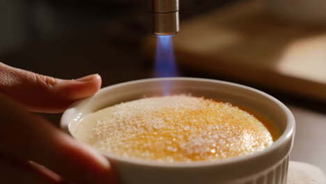 caramelizing creme brulee with a kitchen torch
