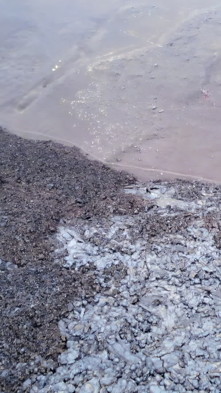 Primer plano de hielo derritiéndose y barro en suelo congelado