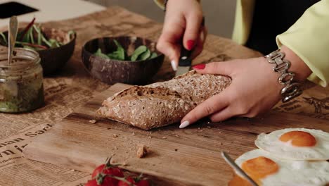 cortando una baguette en la mitad por una mujer chef en una cocina