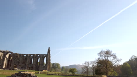 establishing shot revealing bolton abbey ruins on a beautiful sunny summer’s morning in yorkshire, england